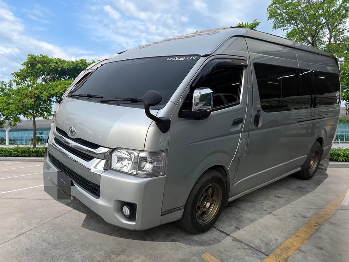 รถตู้ Toyota ของ SanookCar พร้อมฉากหลังจุดรับส่งที่ตกแต่งใหม่